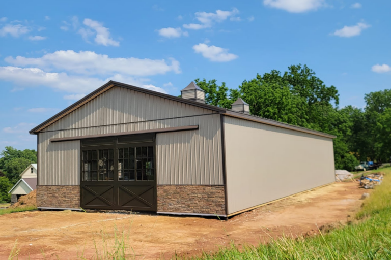 beige pole barn with sliding doors and cobblestone